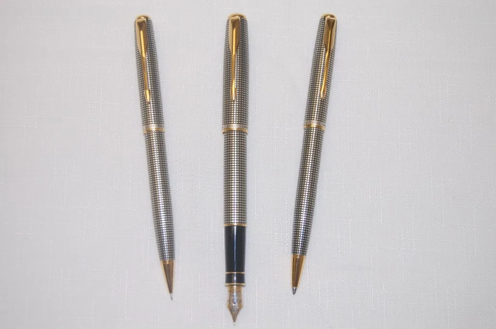 Three-piece silver grid-pattern writing instrument set with gold-tone clips and trim